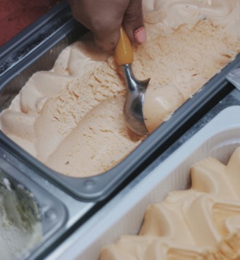 A student scooping ice cream on their summer job.